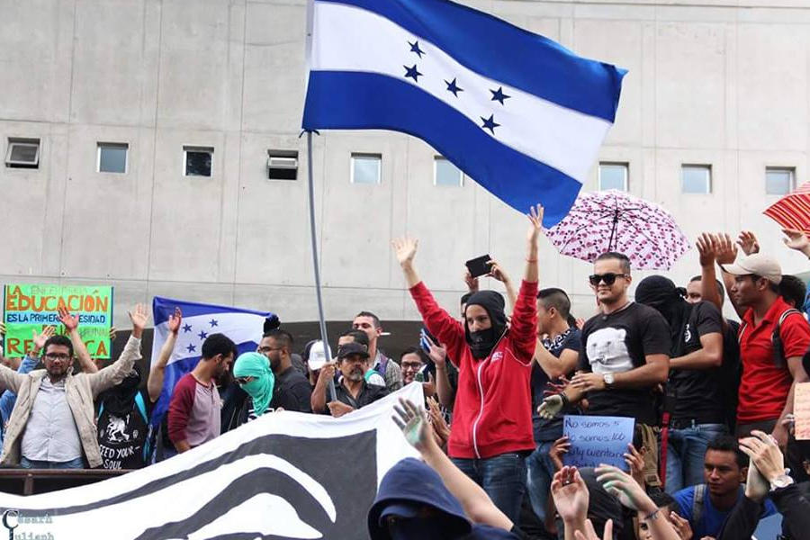 Personas protestan en la calle, con la bandera hondureña