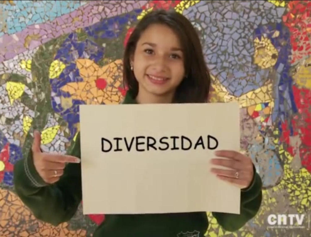 Niña sonriendo con cartel en el que se lee