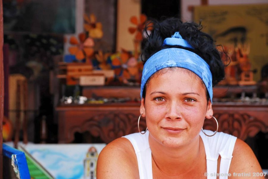 La importancia de la EPJA en la América Latina y el Caribe se ve en la lucha por garantizar el acceso al conocimiento como un derecho humano. La imagen de una mujer blanca con cabello negro atado, sonriendo, ilustra el texto sobre publicaciones que cuentan la EPJA en la región de América Latina y el Caribe.