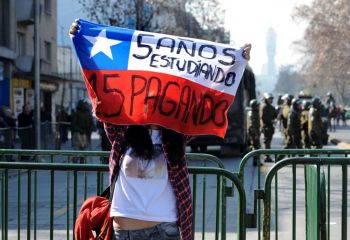 Una estudiante secundarista con la bandera de Chile, donde se lee 