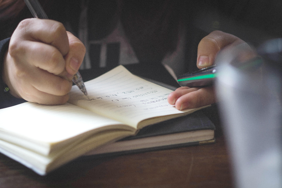 Manos escribiendo en un cuaderno