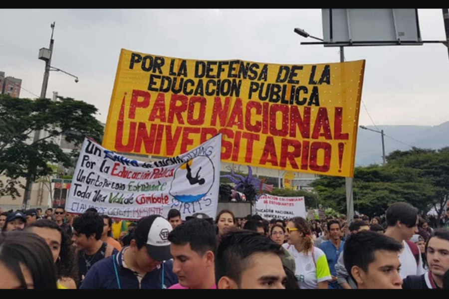 Foto de la marcha de estudiantes en Colombia, con un cartel amarillo en el cual se lee 