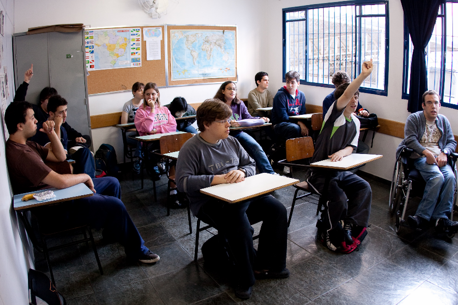 Foto de una sala de clase, con un niño en una silla de ruedas en la primera fila